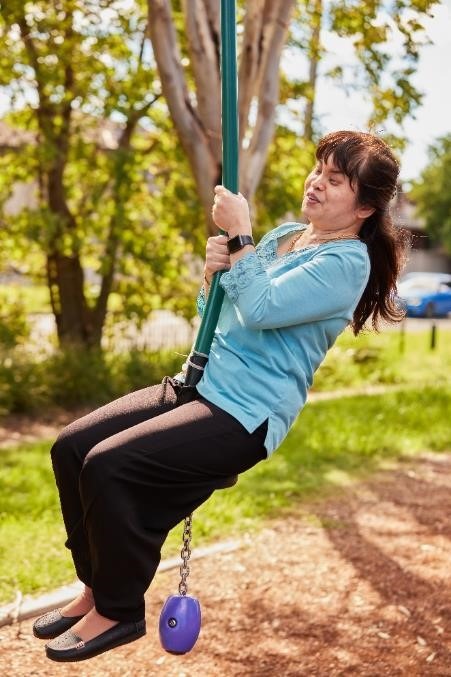 A side-on shot of a woman smiling while on a flying fox.