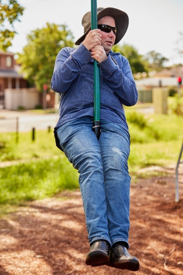 A man smiling while on a flying fox.