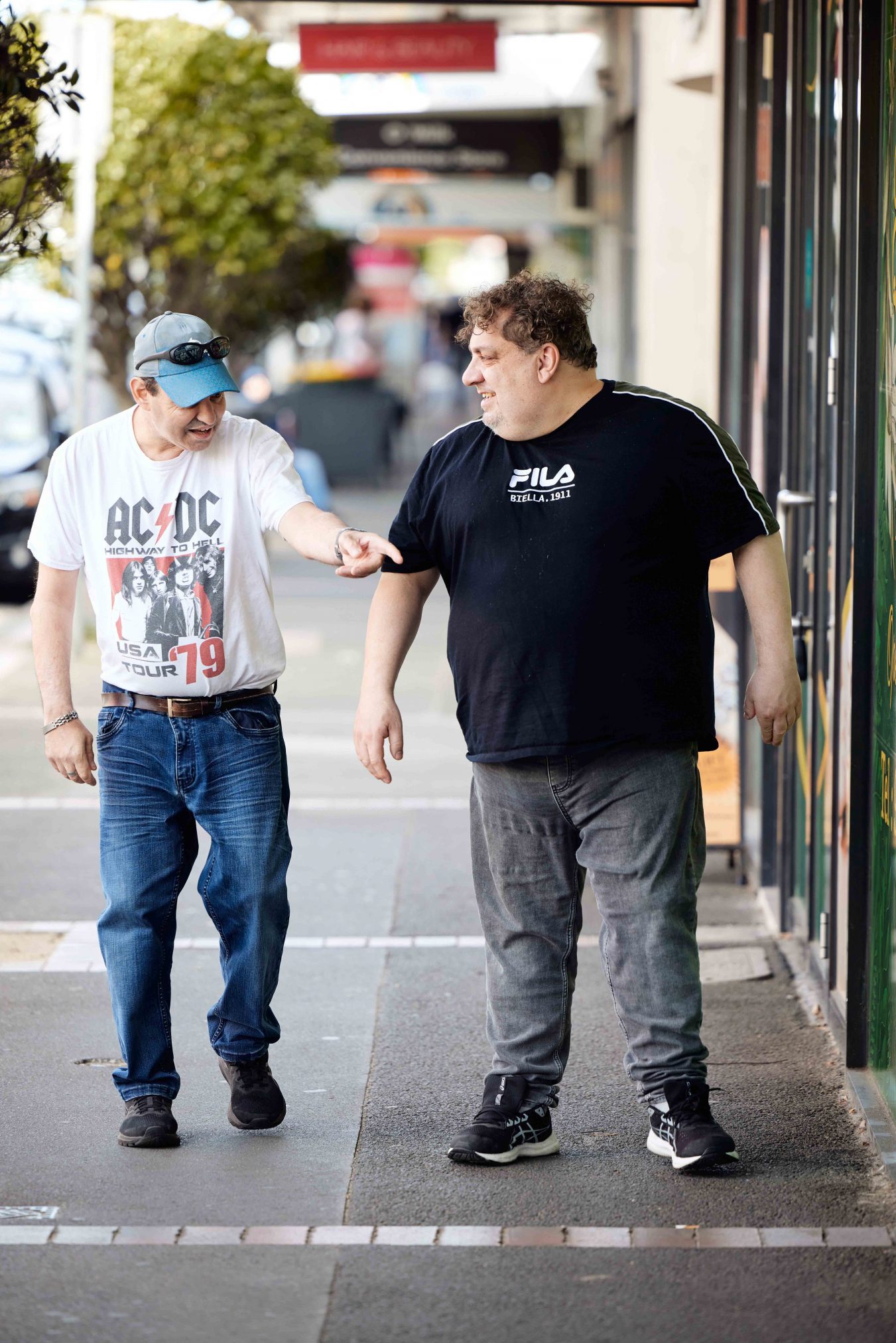 Client and Support Worker looking in shop windows on footpath. 