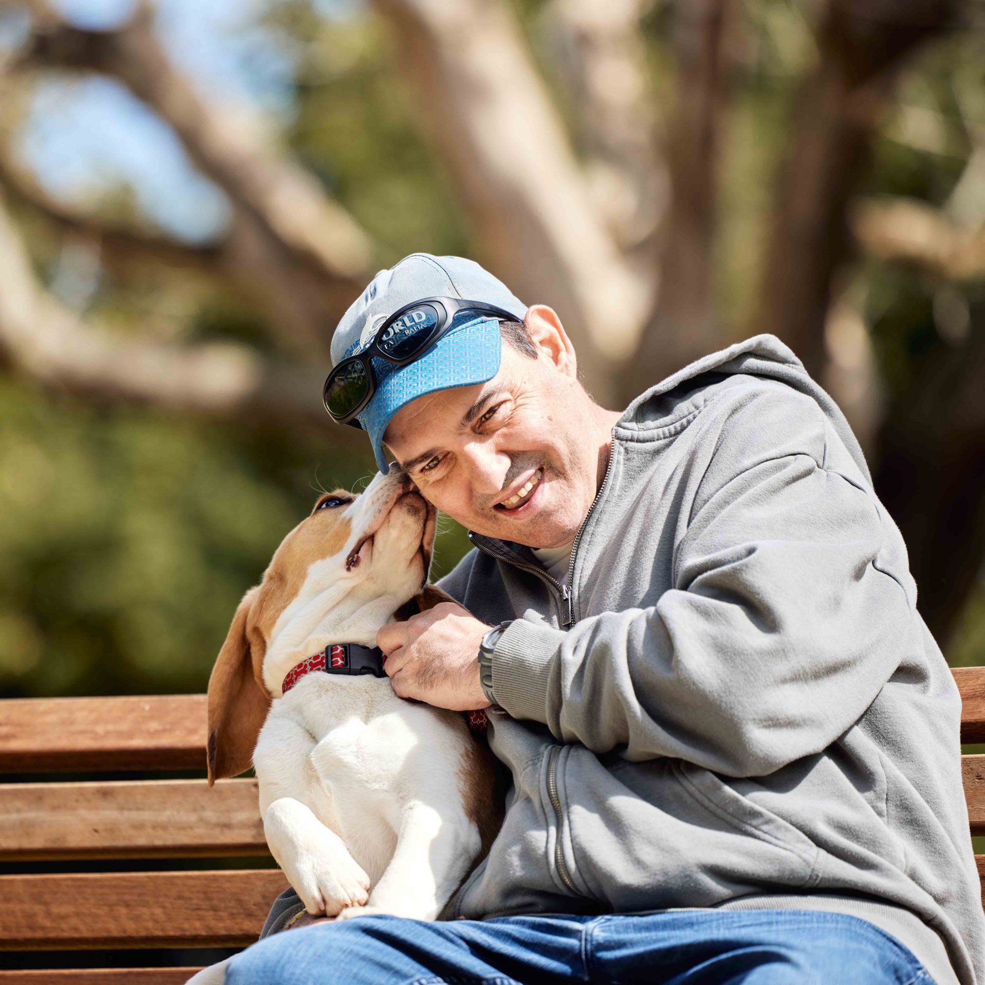 Client is laughing because dog is licking his cheek.